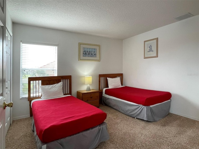 bedroom featuring a textured ceiling and carpet