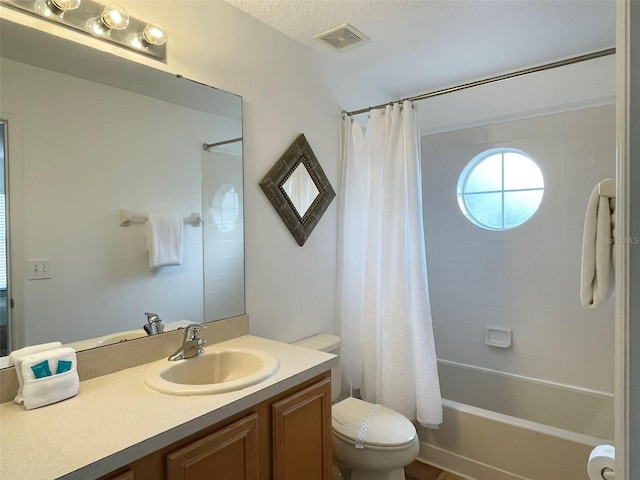 full bathroom with a textured ceiling, vanity, toilet, and shower / bath combo with shower curtain