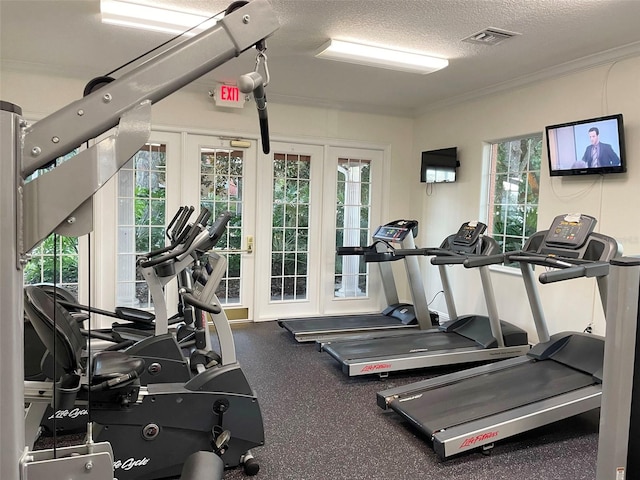 gym with ornamental molding and a textured ceiling