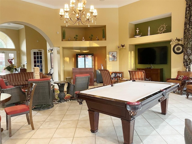 game room with a high ceiling, plenty of natural light, and light tile patterned floors