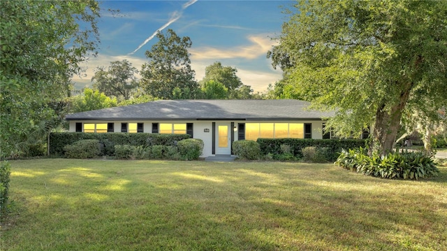 ranch-style home featuring a lawn