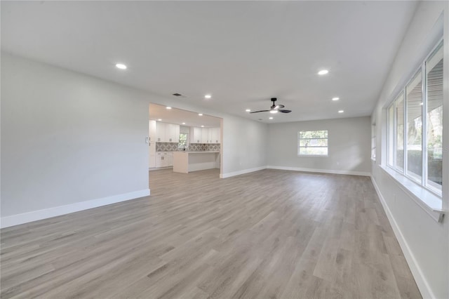 unfurnished living room featuring light wood-type flooring and ceiling fan