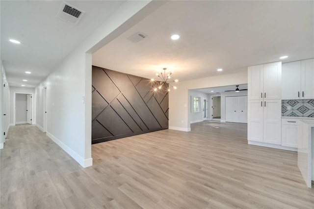 hallway featuring light wood-type flooring and a chandelier