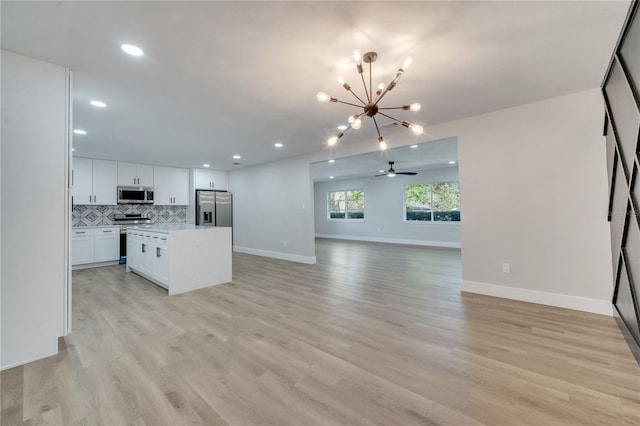 kitchen featuring appliances with stainless steel finishes, a center island, light hardwood / wood-style flooring, and white cabinets