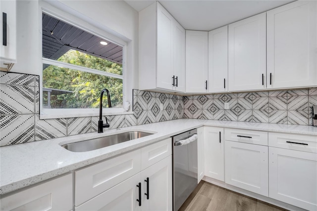 kitchen featuring light hardwood / wood-style flooring, dishwasher, white cabinetry, and sink