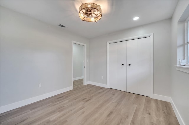 unfurnished bedroom with light hardwood / wood-style floors and a closet