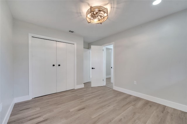 unfurnished bedroom with light hardwood / wood-style floors and a closet