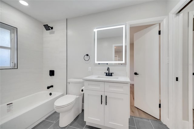 full bathroom featuring tiled shower / bath, vanity, toilet, and tile patterned floors