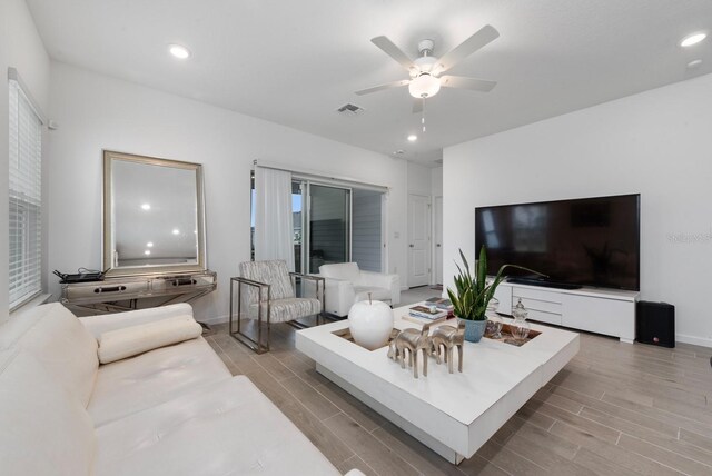 living room featuring ceiling fan and light hardwood / wood-style floors