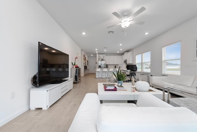 living room featuring light hardwood / wood-style floors and ceiling fan