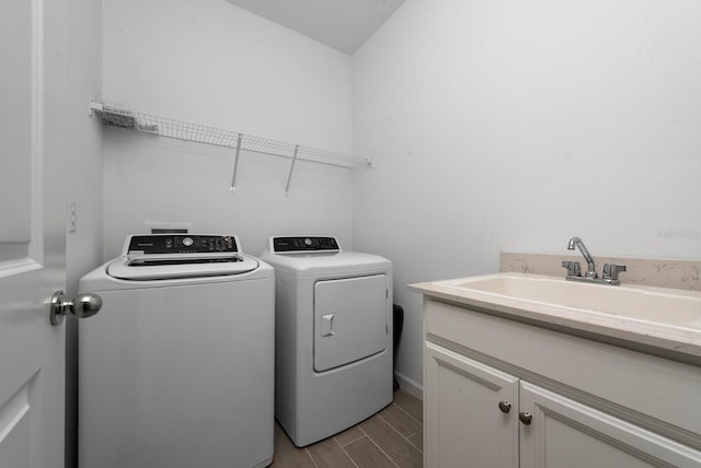 laundry area with separate washer and dryer, cabinets, light wood-type flooring, and sink