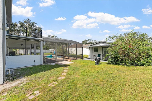 view of yard featuring a patio, a pool with hot tub, ceiling fan, and glass enclosure