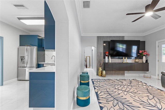 living room featuring crown molding, sink, and ceiling fan