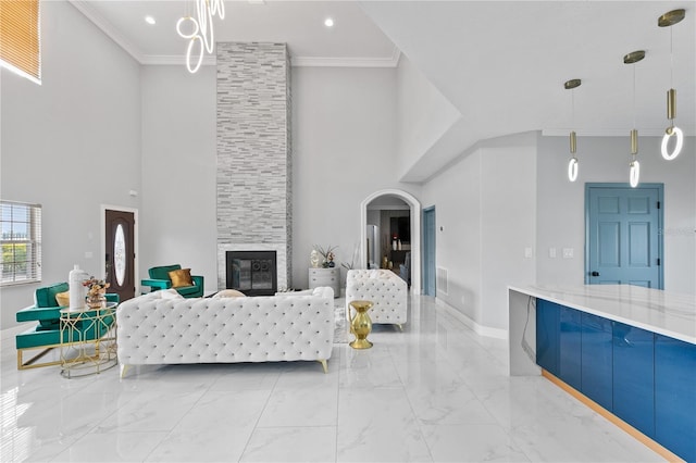 living room with crown molding, a high ceiling, and a fireplace