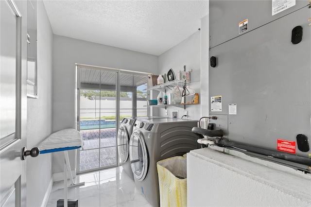 laundry area with a textured ceiling and washing machine and dryer