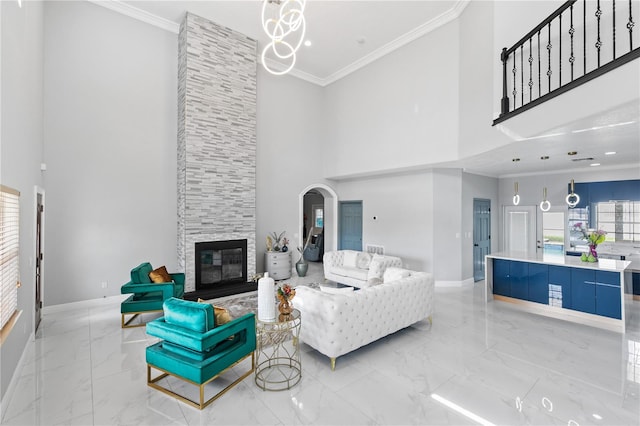 living room featuring ornamental molding, a fireplace, and a towering ceiling