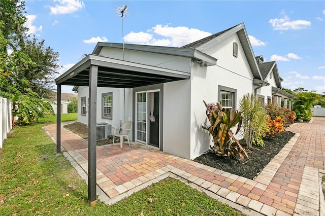 rear view of property featuring a patio area and a carport