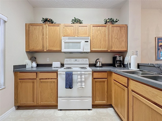 kitchen featuring a textured ceiling, sink, and white appliances