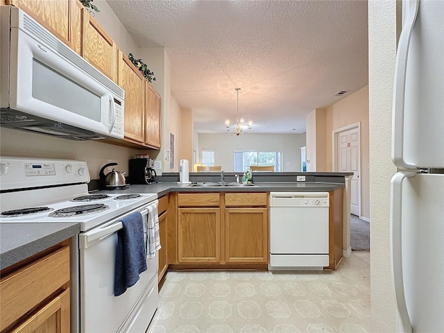 kitchen with white appliances, an inviting chandelier, sink, a textured ceiling, and kitchen peninsula