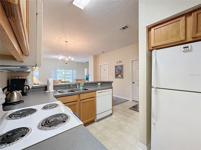 kitchen with sink, a notable chandelier, a textured ceiling, decorative light fixtures, and white appliances