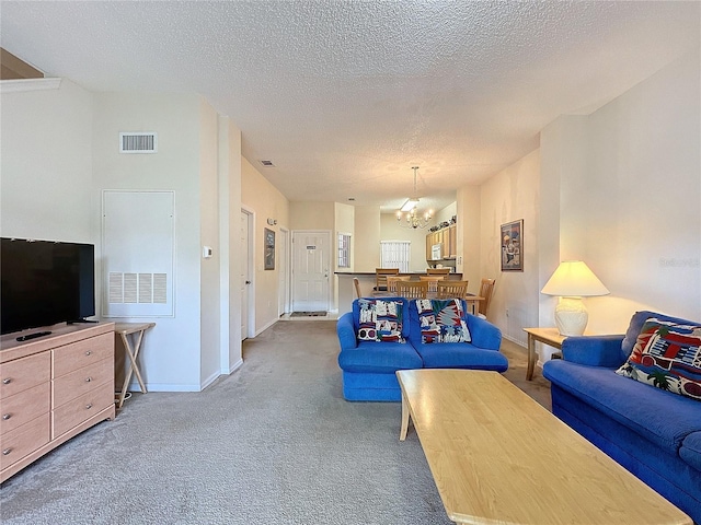 living room featuring carpet, a textured ceiling, and an inviting chandelier