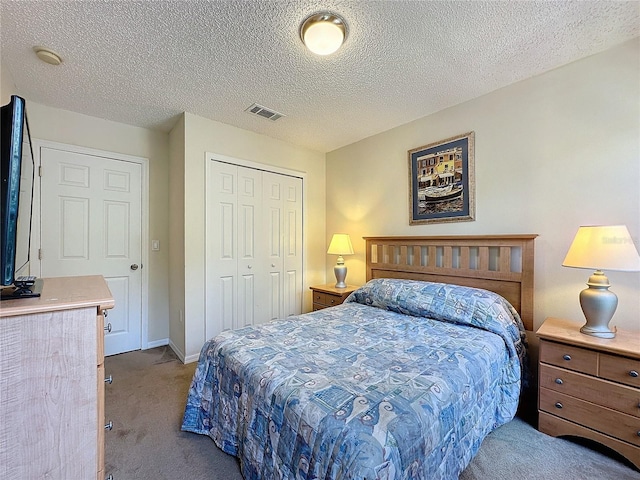 bedroom with a closet, light colored carpet, and a textured ceiling