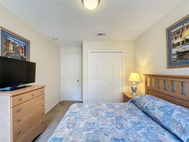 carpeted bedroom with a textured ceiling and a closet