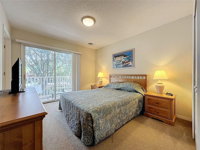 bedroom with access to exterior, light carpet, and a textured ceiling