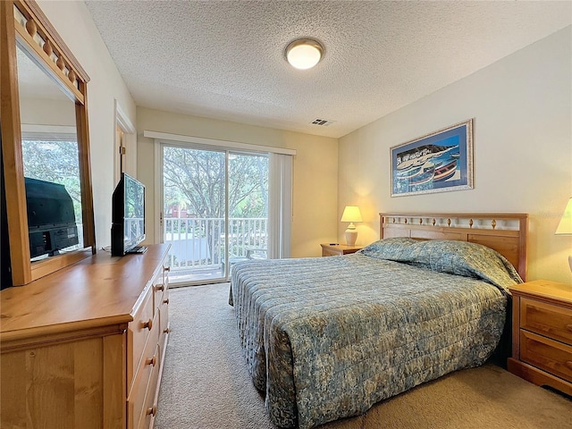 bedroom featuring multiple windows, carpet floors, and a textured ceiling