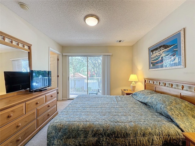 carpeted bedroom featuring a textured ceiling and access to outside