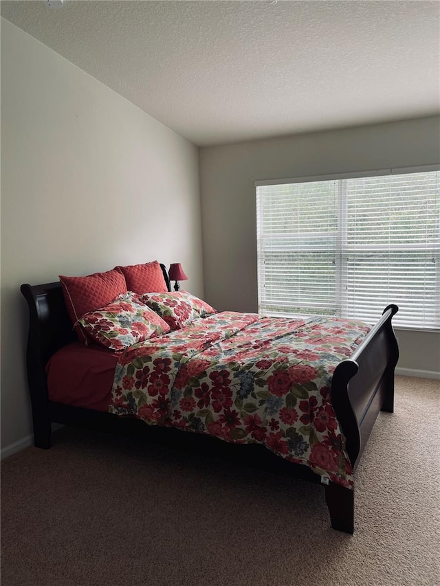 bedroom with carpet floors and a textured ceiling