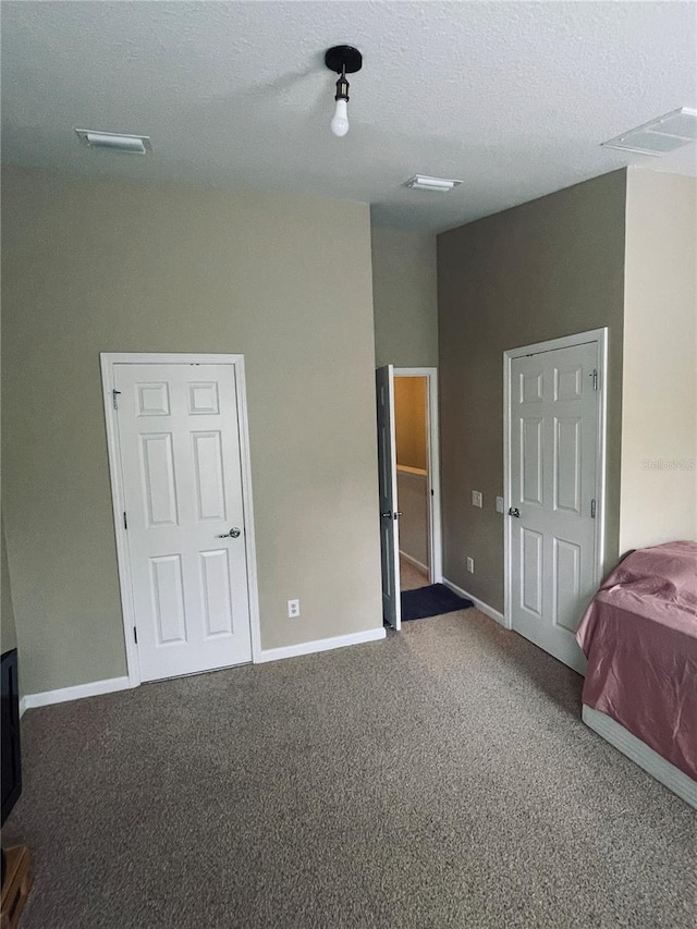 unfurnished bedroom with a textured ceiling and carpet flooring