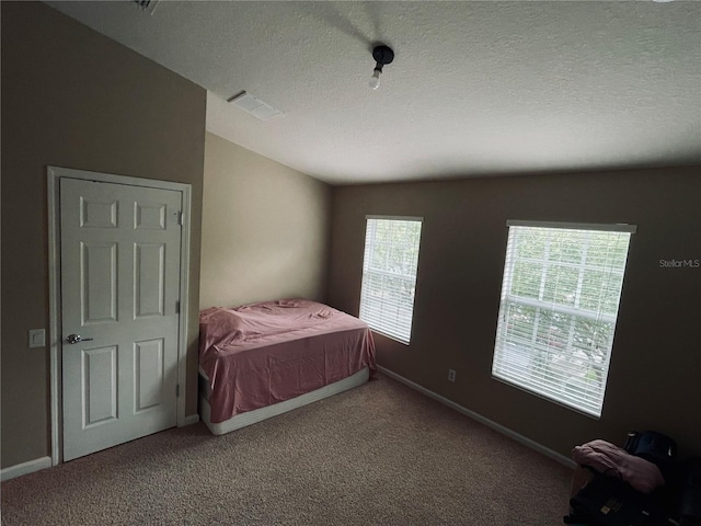 bedroom with a textured ceiling and carpet flooring