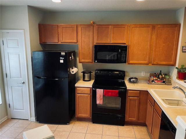 kitchen with black appliances, sink, and light tile patterned floors