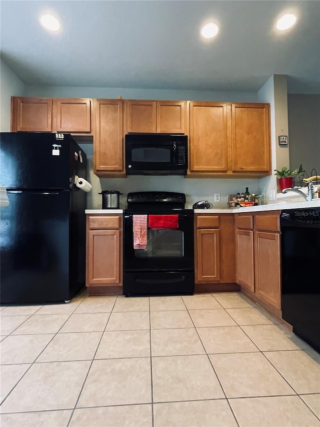 kitchen with light tile patterned flooring and black appliances