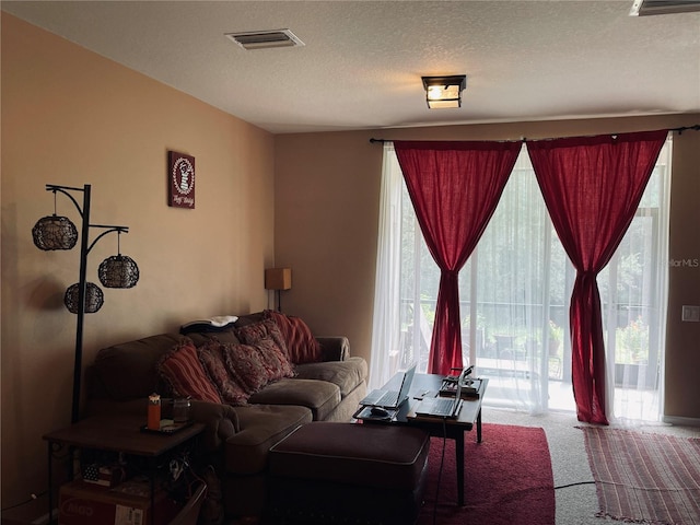 carpeted living room featuring a textured ceiling