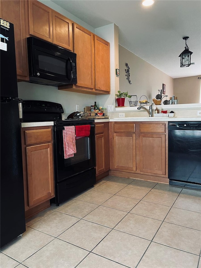 kitchen featuring light tile patterned flooring, kitchen peninsula, and black appliances