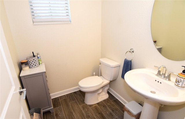 bathroom with toilet, hardwood / wood-style flooring, and sink