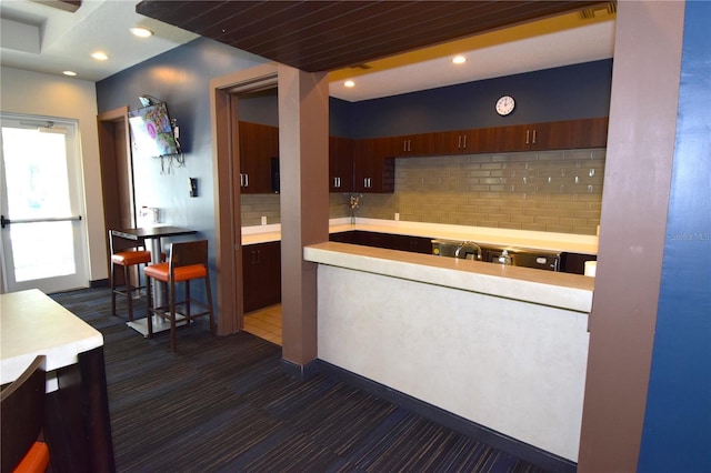 kitchen with decorative backsplash and a kitchen bar