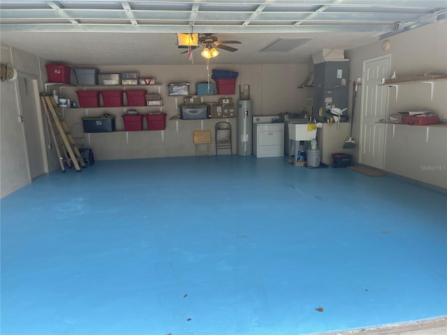 garage featuring ceiling fan, water heater, sink, and washing machine and clothes dryer