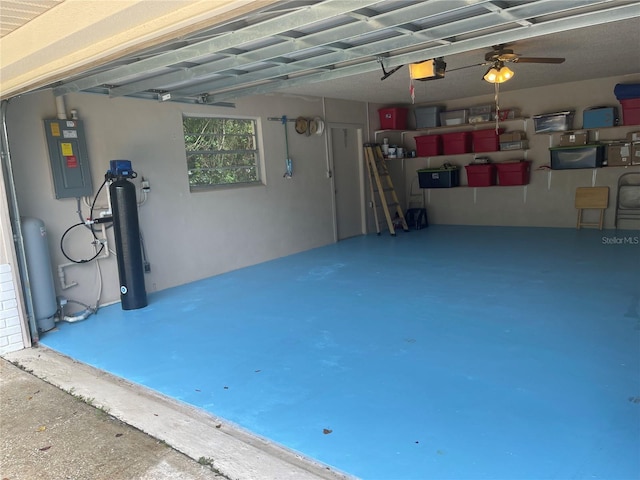 garage with a garage door opener, electric panel, and ceiling fan