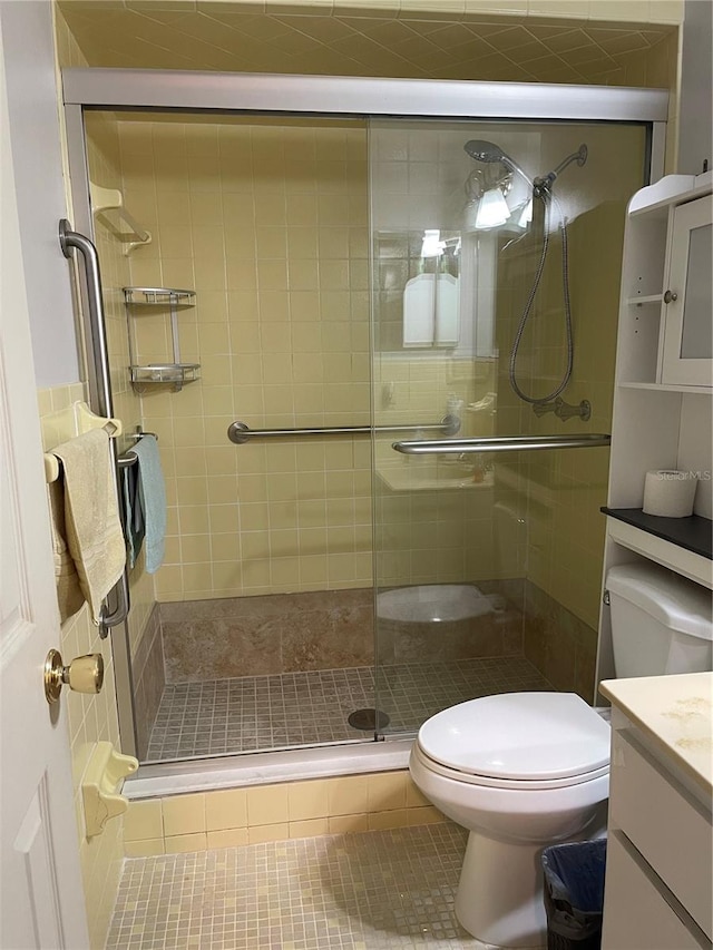 bathroom featuring vanity, a shower with shower door, toilet, and tile patterned flooring