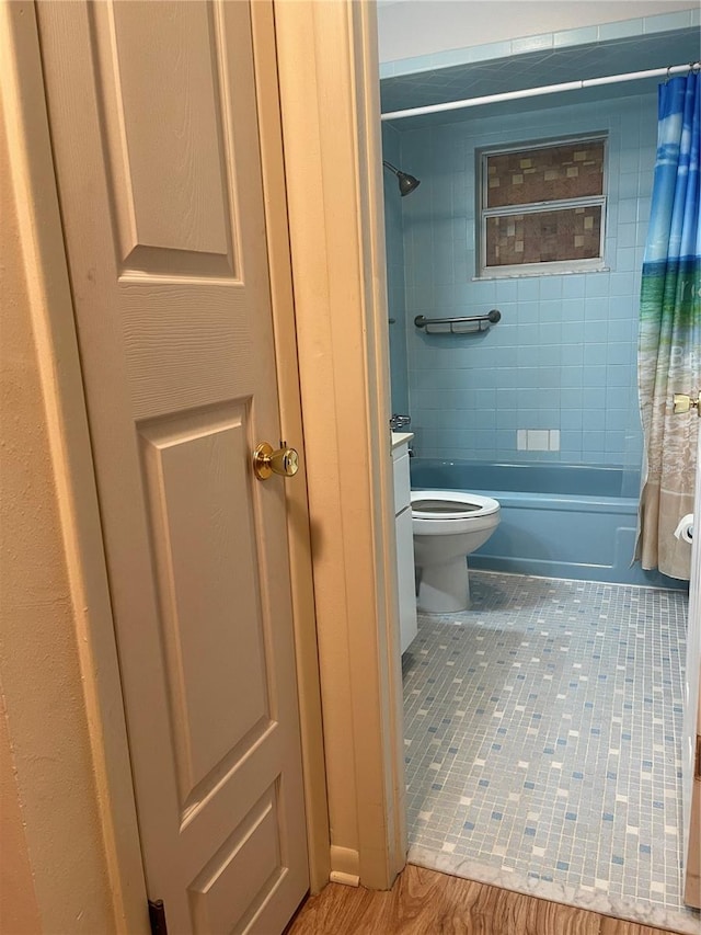 bathroom featuring shower / bath combination with curtain, tile patterned flooring, and toilet