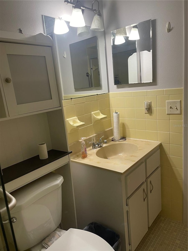 bathroom with vanity, tile walls, and toilet