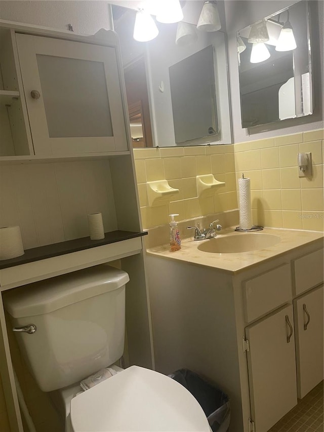 bathroom with backsplash, vanity, and toilet