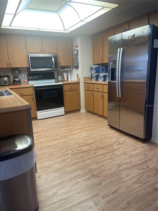 kitchen featuring light hardwood / wood-style floors, sink, stainless steel appliances, and backsplash