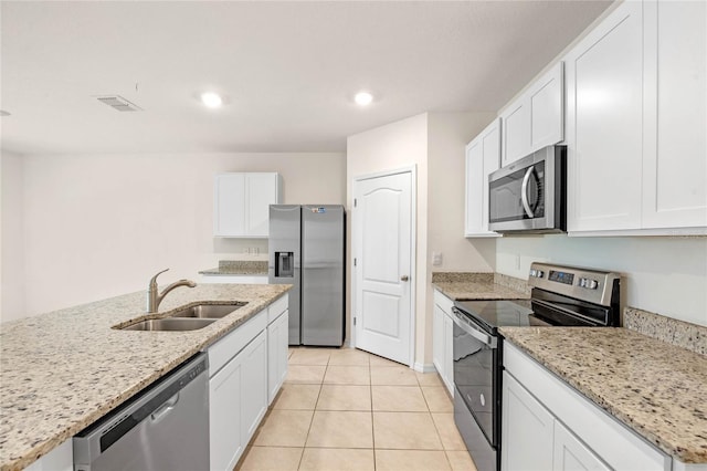 kitchen featuring light stone counters, white cabinets, light tile patterned floors, sink, and appliances with stainless steel finishes