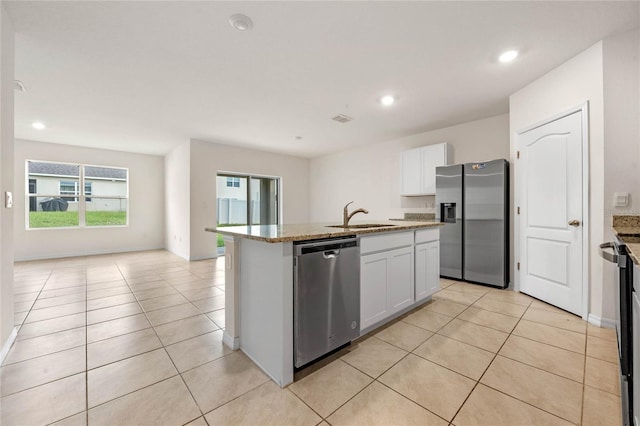 kitchen featuring an island with sink, white cabinets, sink, appliances with stainless steel finishes, and light tile patterned floors