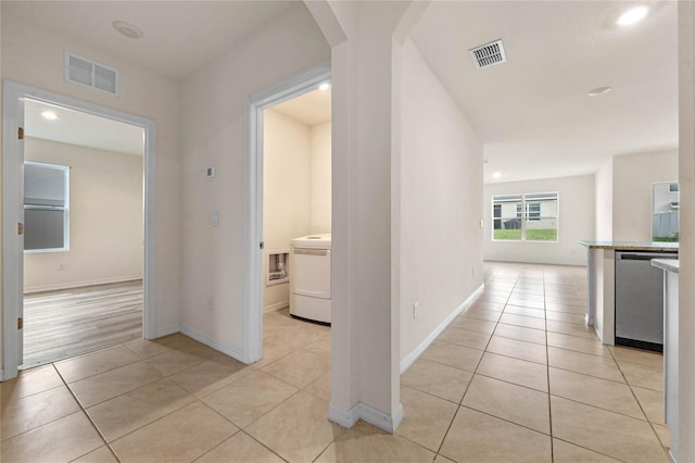 hallway with light tile patterned floors and washer / clothes dryer