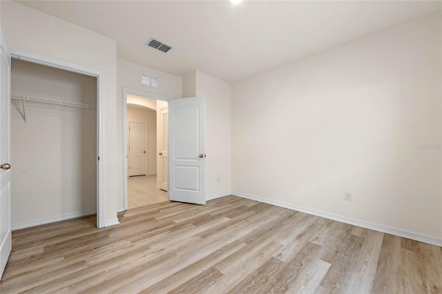 unfurnished bedroom featuring a closet and light hardwood / wood-style floors